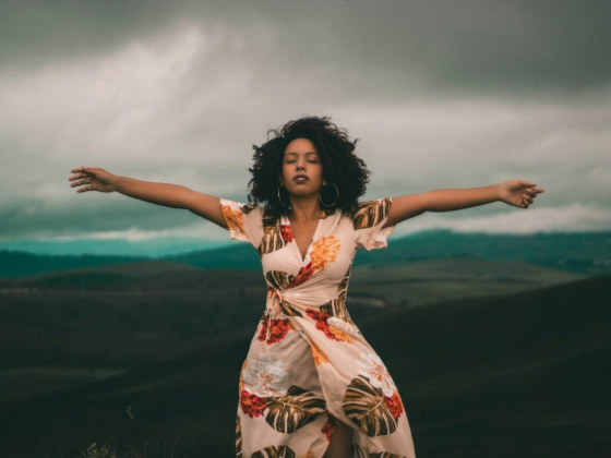 An African American woman with an hourglass figure rocking a floral-print dress