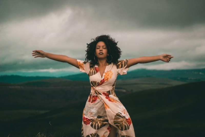 An African American woman with an hourglass figure rocking a floral-print dress