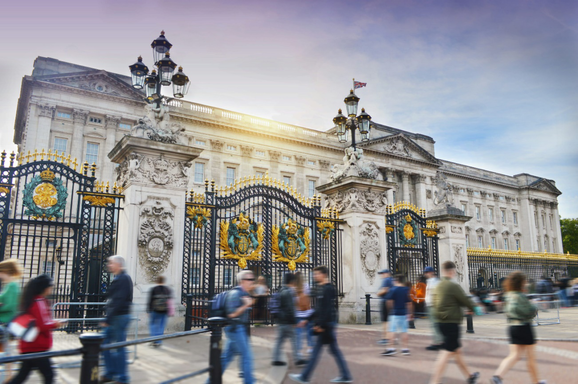 A dynamic view of Buckingham Palace during a busy day with pedestrians in motion.