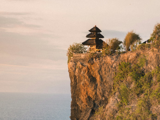 A cliffside view of Uluwatu Temple with the Indian Ocean in the background.