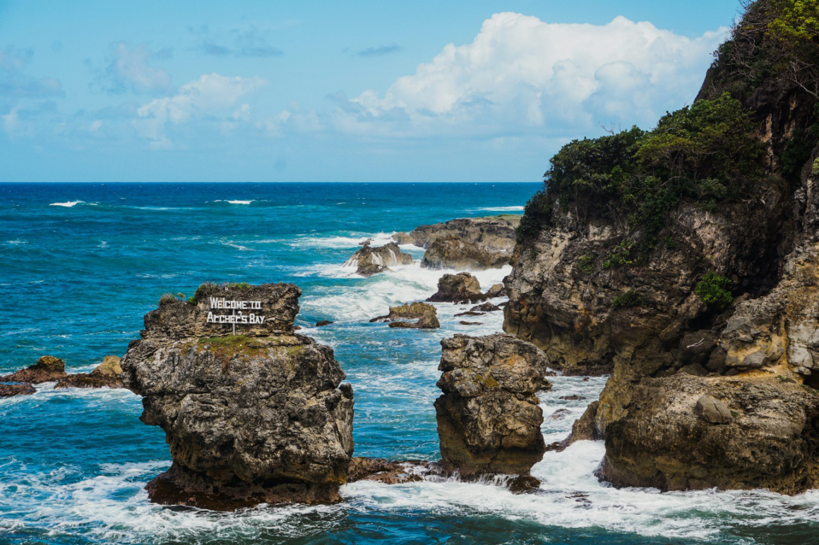 Rugged coastline at Archer’s Bay in Barbados with waves crashing against rocks.