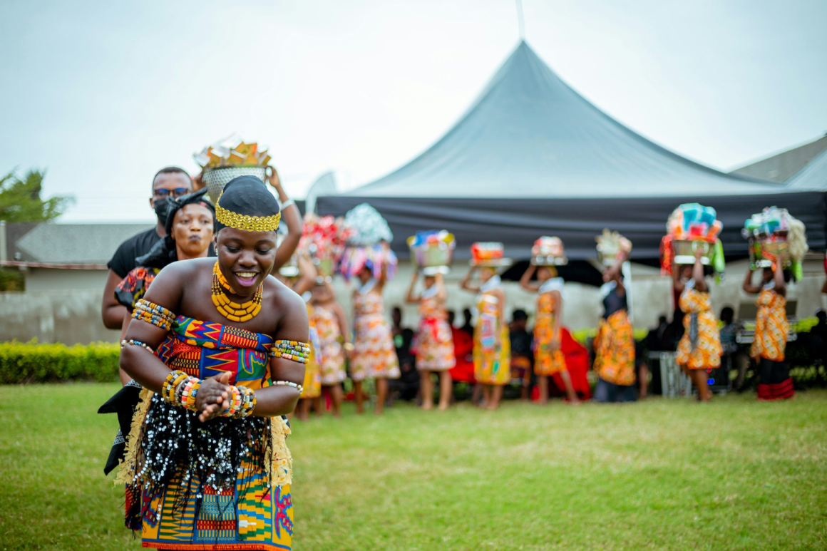 Ghanaian women dressed in traditional attire performing a cultural dance.