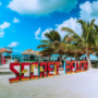 Colorful 'Secret Beach' sign at a vibrant beach location in Belize