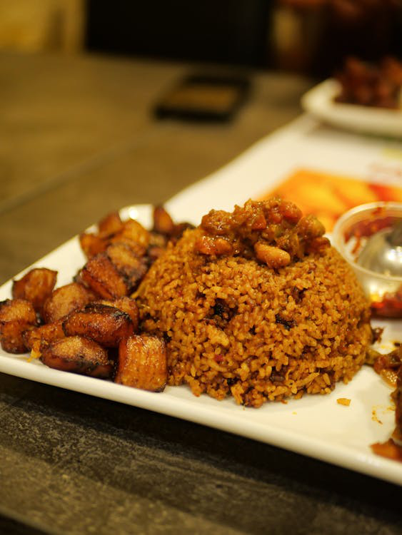 Traditional Ghanaian jollof rice with fried plantains