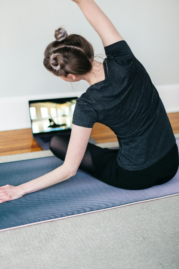 A woman stretching on a yoga mat.