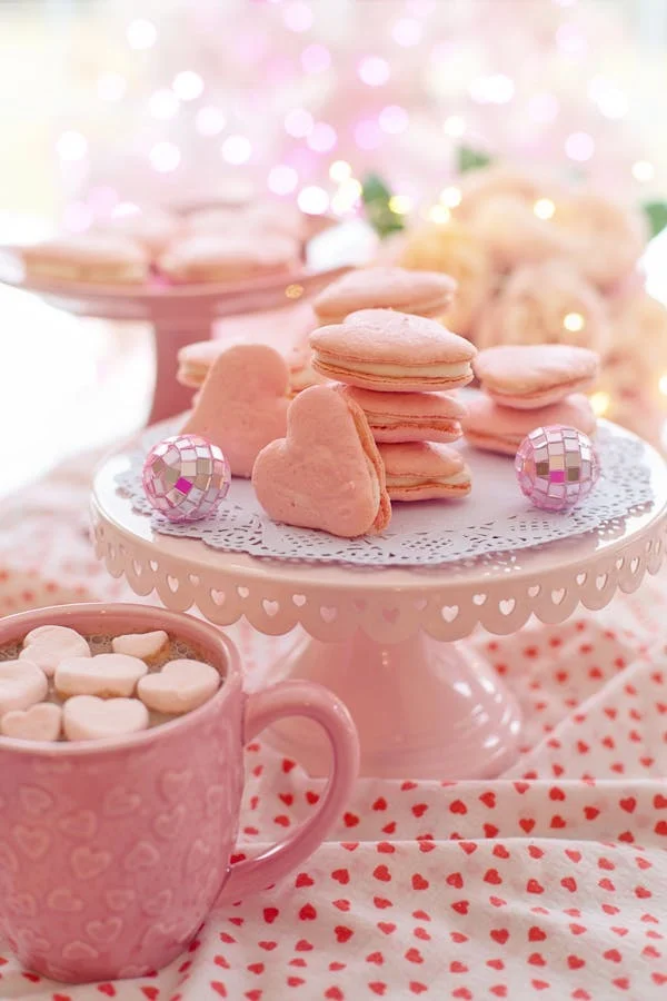 Freshly baked heart-shaped cookies decorated with icing and sprinkles.