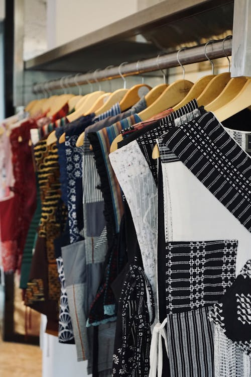 A colorful rack of printed dresses in a vintage thrift store, featuring floral and patterned styles