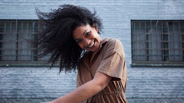 A confident woman smiling with the wind in her hair, embracing joy and freedom.