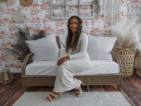 A stylish woman sitting in a beautifully decorated small living space with cozy accents.
