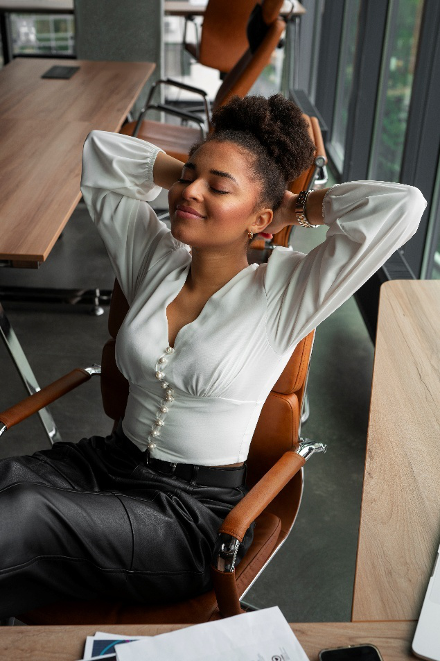 Confident woman relaxing in an office chair with hands behind head
