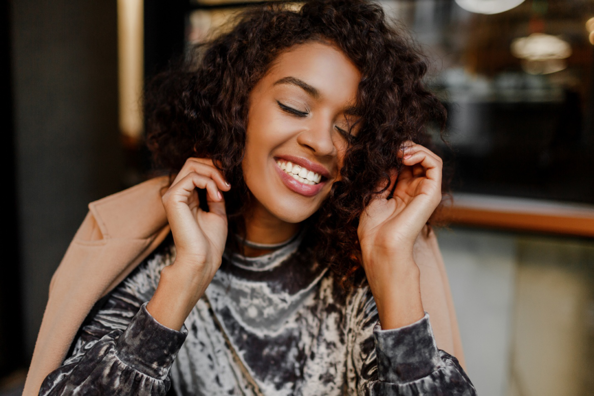 Happy woman smiling with eyes closed, feeling at peace